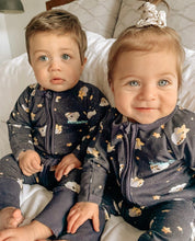 Load image into Gallery viewer, Two babies wearing Santi The Sloth dark grey pajamas with a cloud and star print. The boy has brown hair and the girl has a scrunchie in her hair.